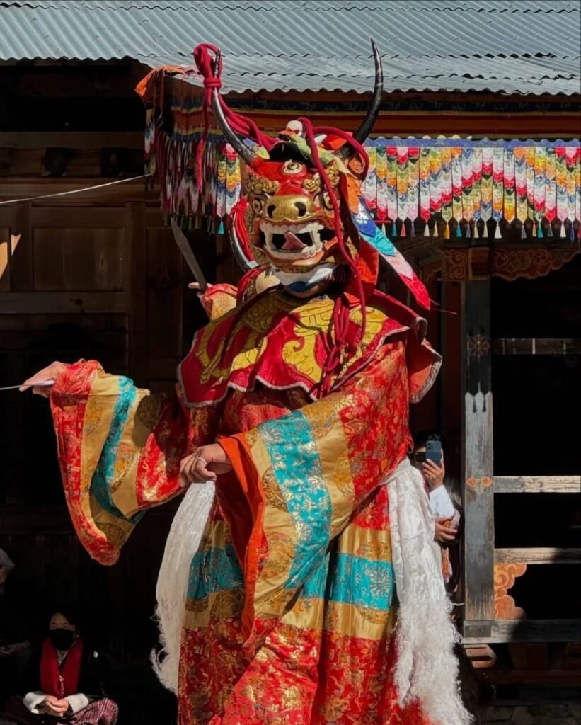Masked dancer in brocade costume at a Bhutanese festival